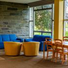 stone walled lounge with large windows and a seating area